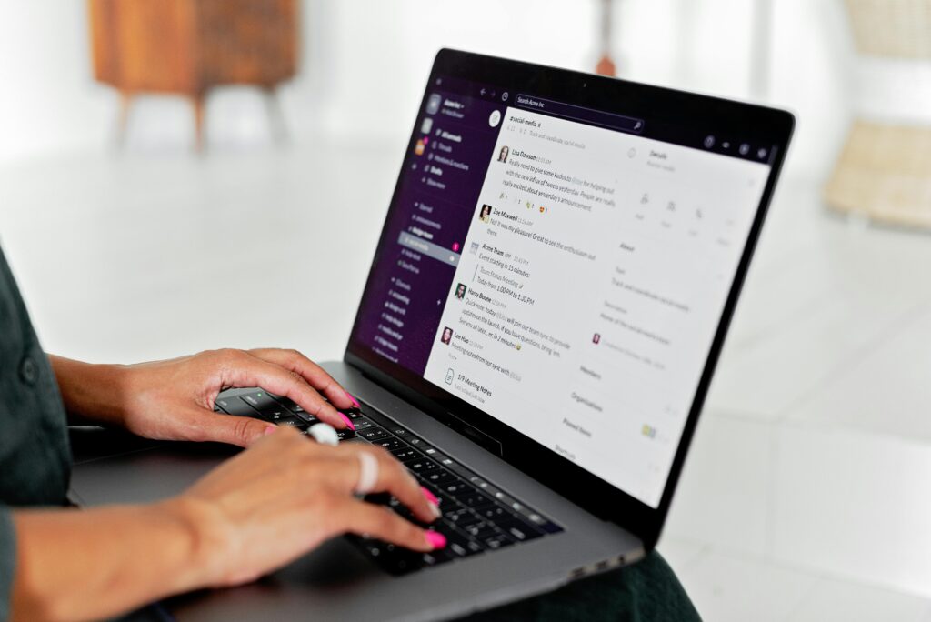 Tela de notebook com pessoa mexendo no slack, ferramenta de colaboração remota.
